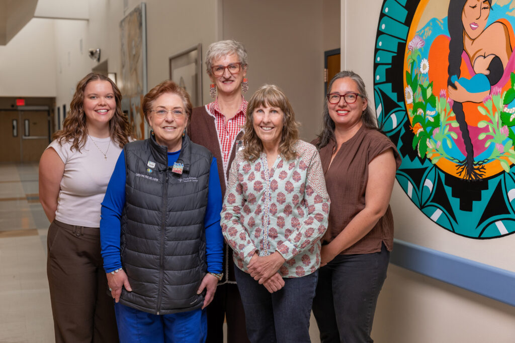 Five members of the Circle of Care family-support network stand together in a hallway at Holy Cross Medical Center.