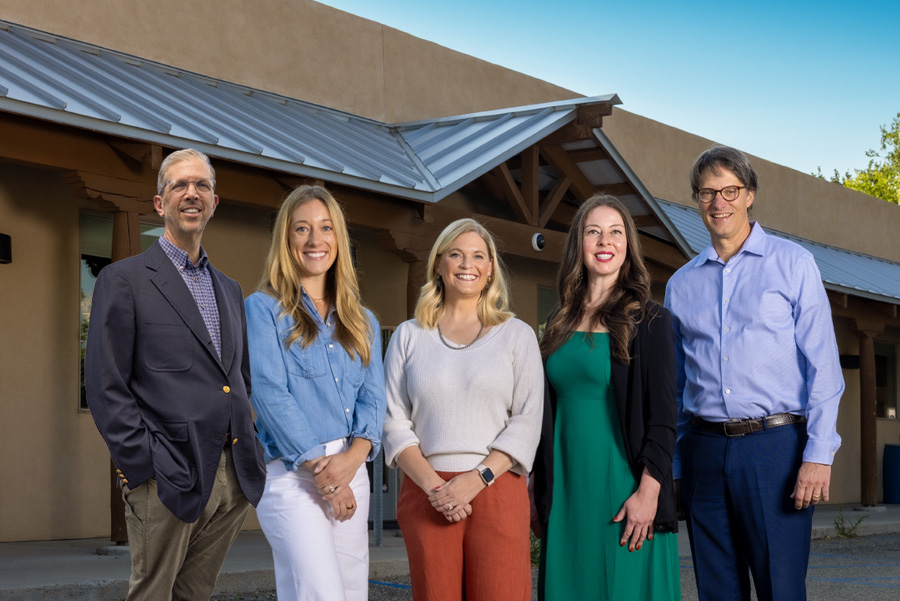 Five professionals stand together outside a building, showcasing teamwork and collaboration for the Home 2026 initiative.
